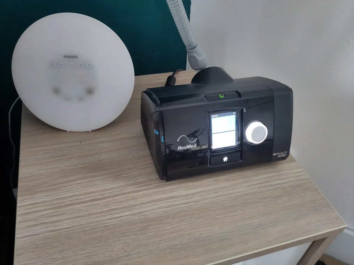 CPAP machine and hose on a bedside table