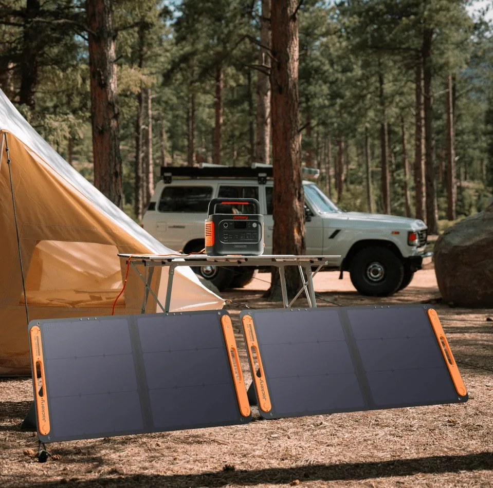 Jackery portable power station and solar panels at a forest campsite